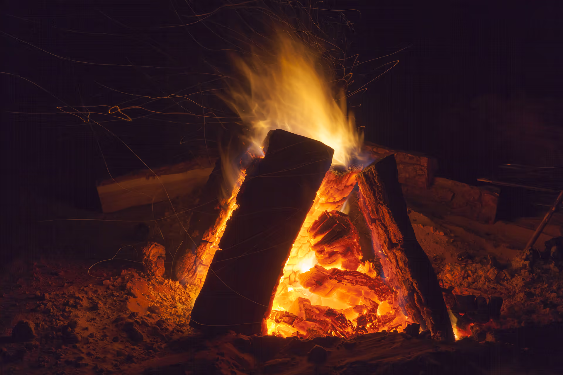 Campfire burning in the Sahara at night under a clear sky