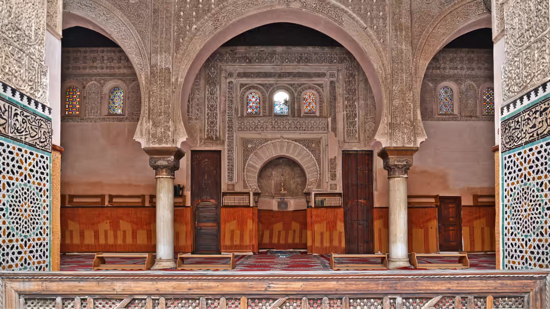 Zellige tilework and carved plaster on the walls of a madrasa in Fez